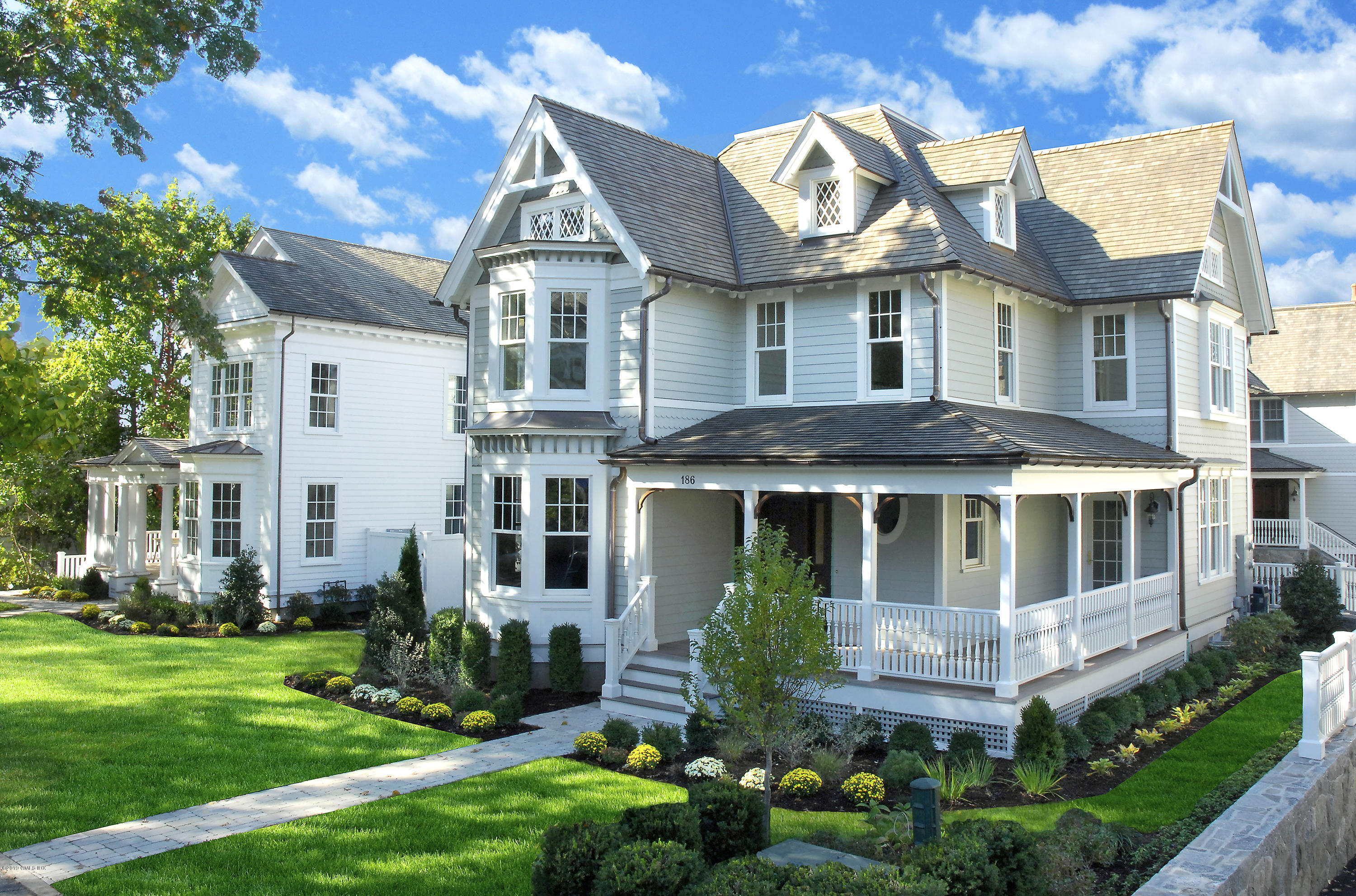 a front view of a house with a yard and potted plants