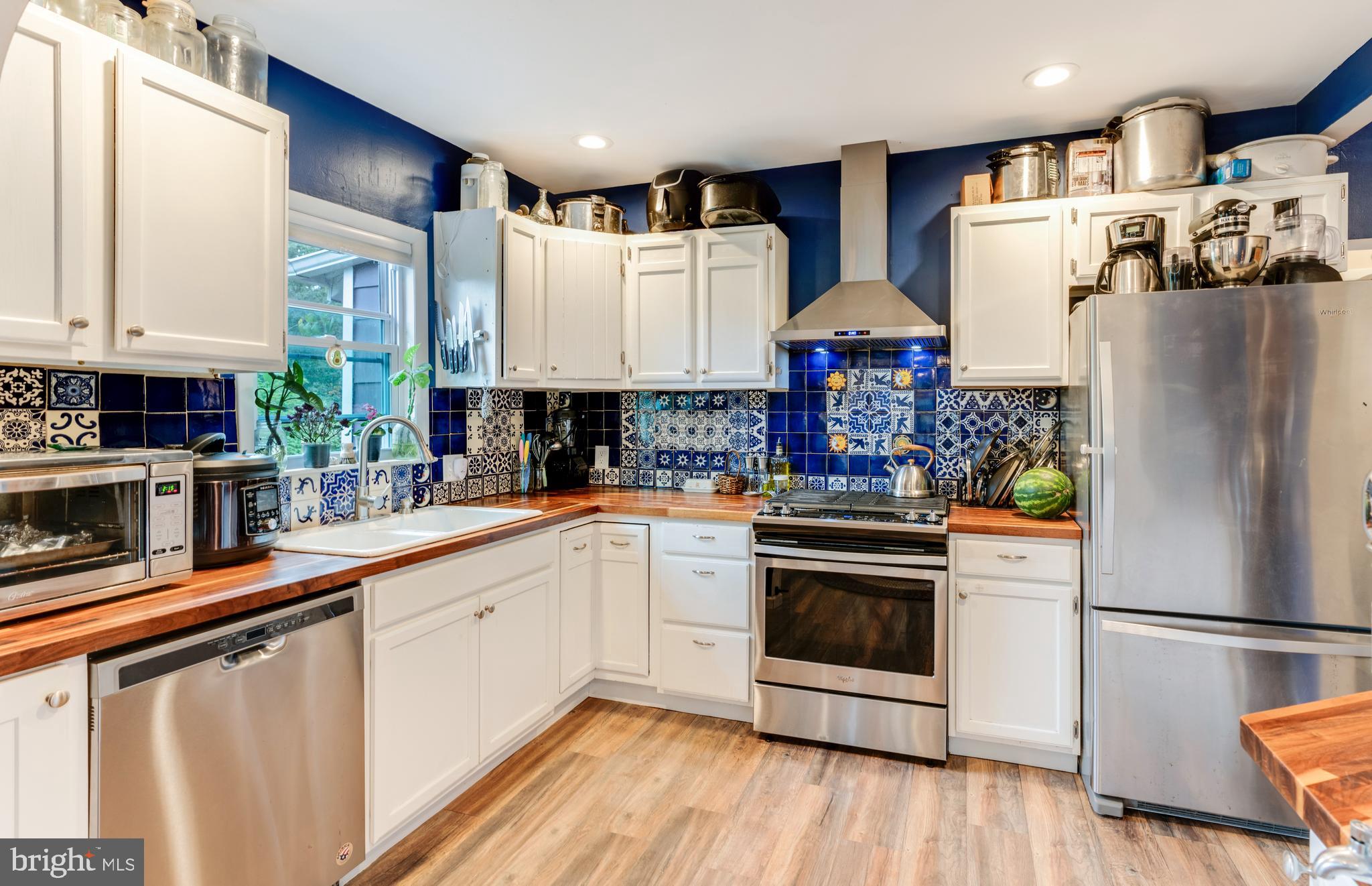 a kitchen with stainless steel appliances a refrigerator sink and cabinets