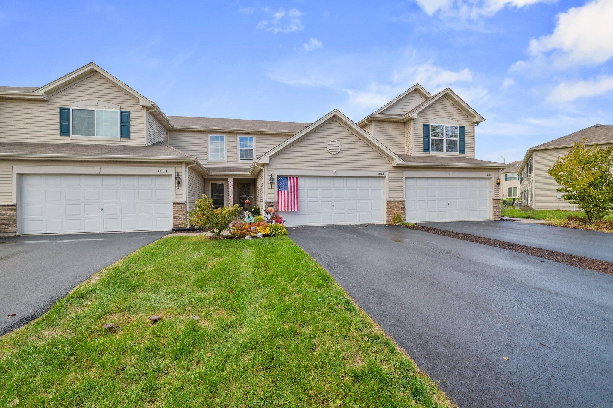 a front view of a house with a yard and garage