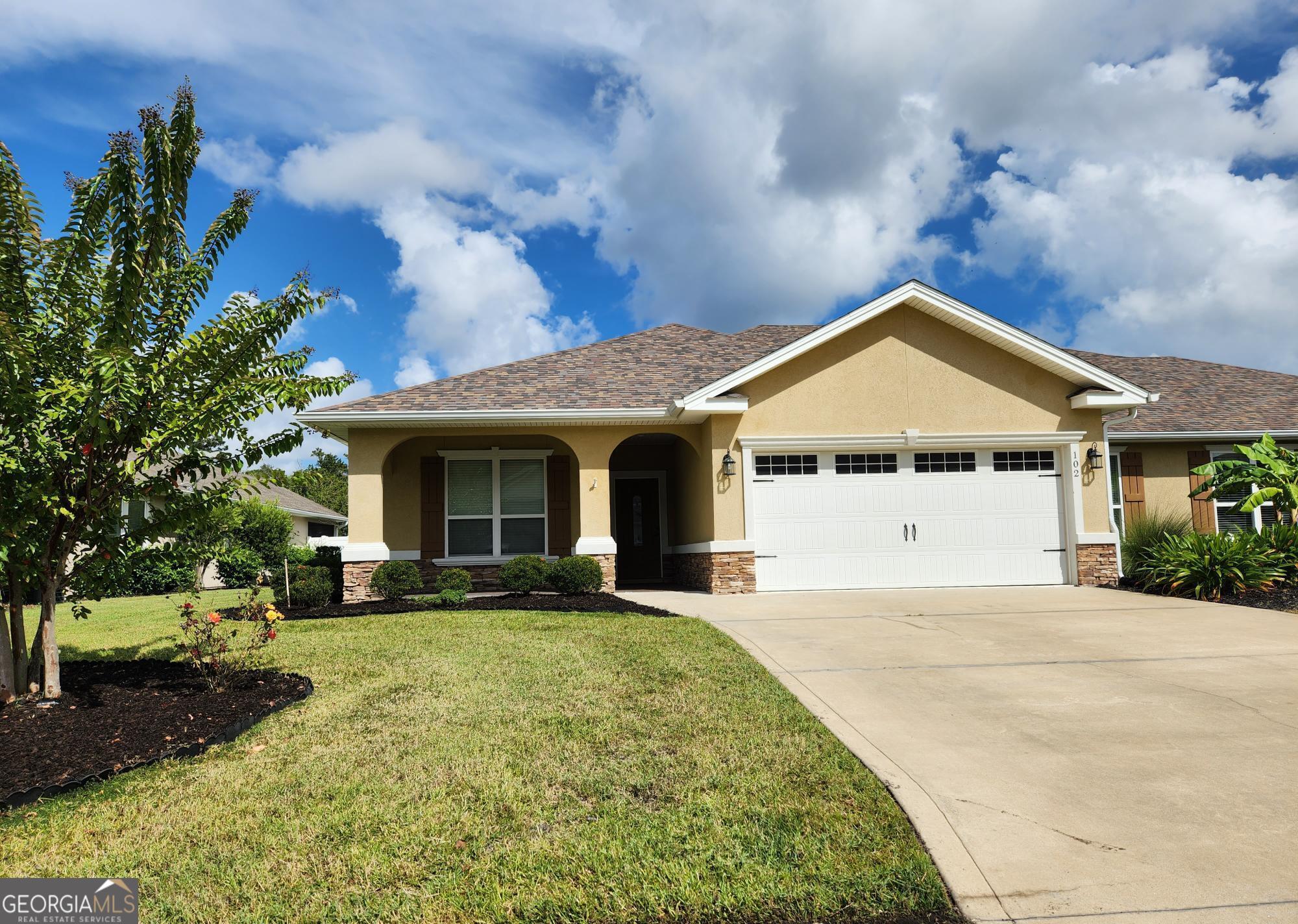 a front view of a house with a garden