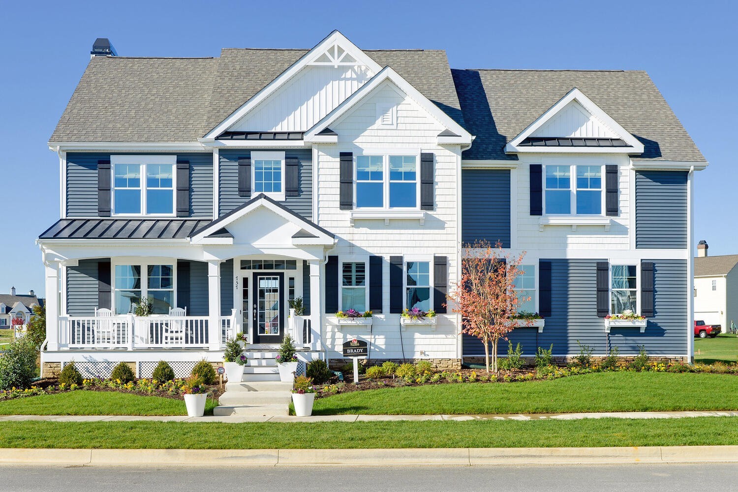 a front view of a residential houses with yard and green space