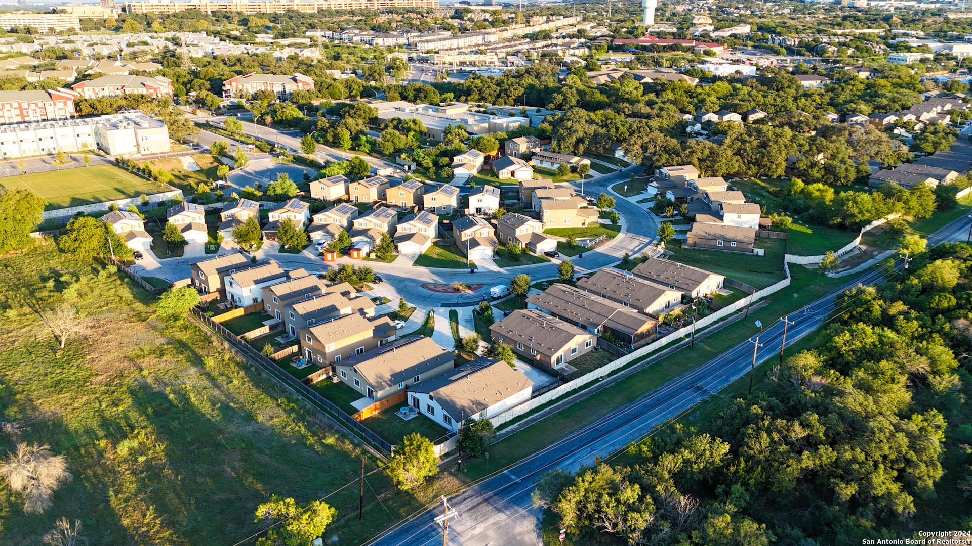 an aerial view of a residential houses with yard