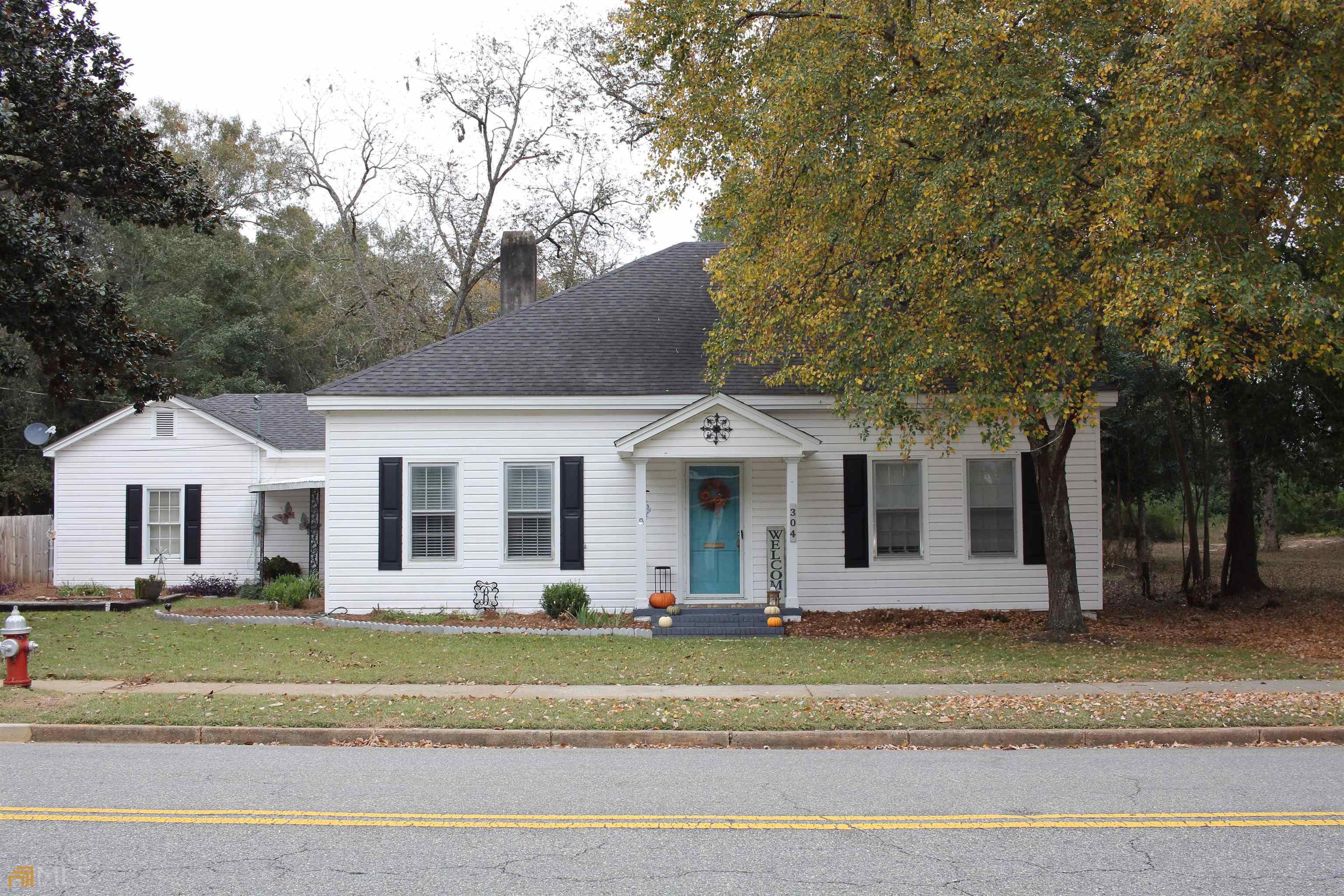 a front view of a house with a yard and palm trees