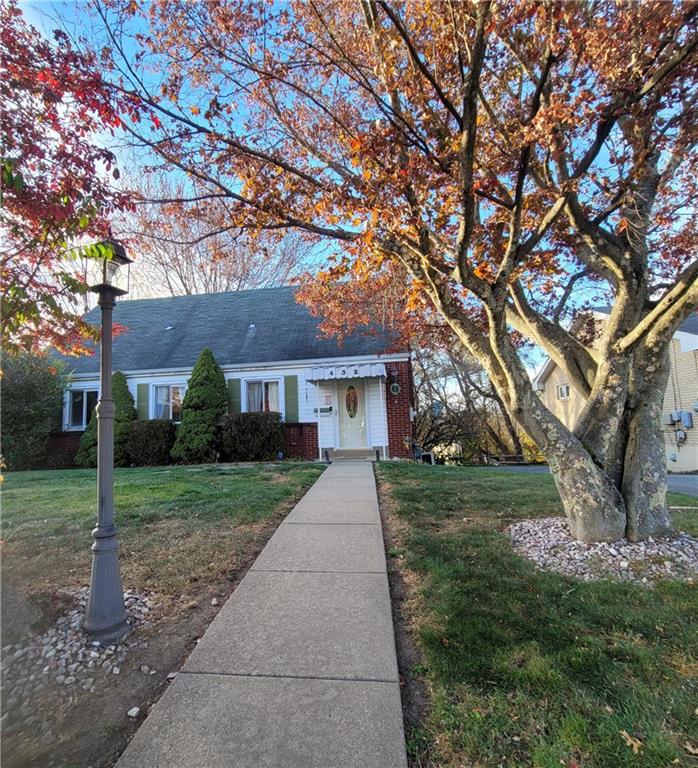 a front view of a house with a yard and trees