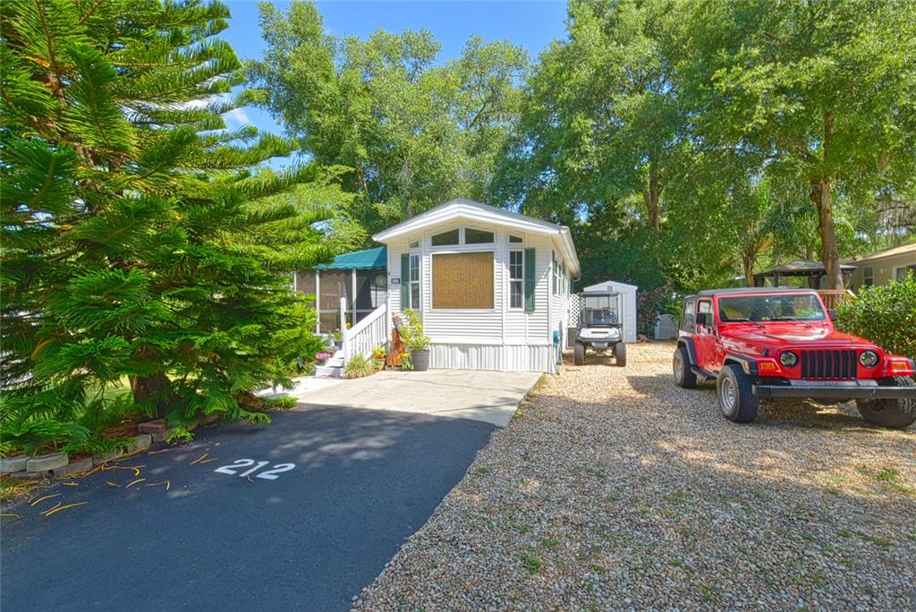 a front view of a house with a garden and parking