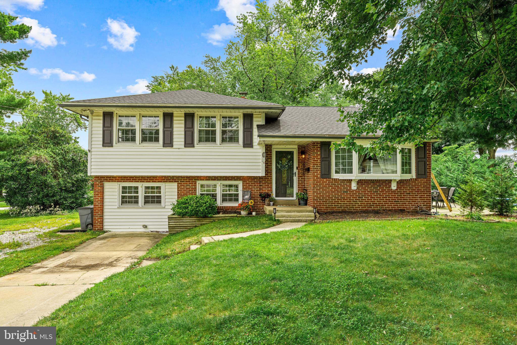 a front view of a house with a yard and trees