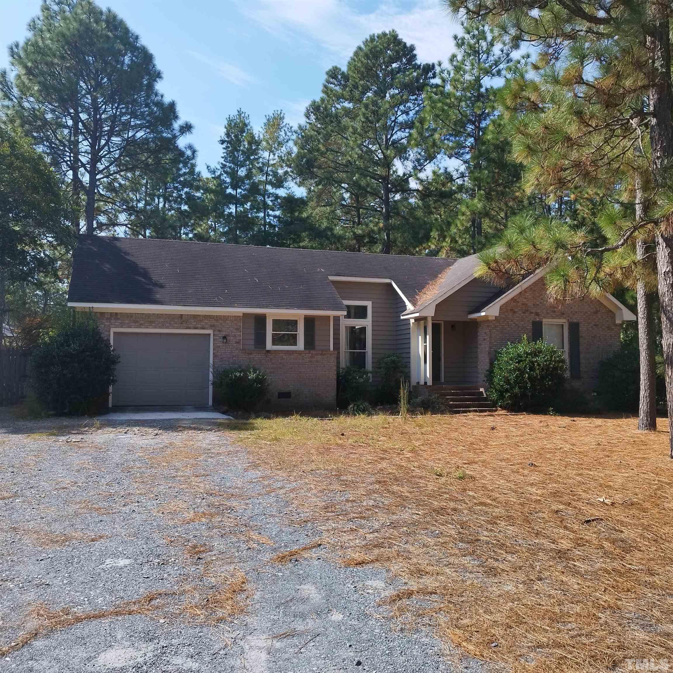 a front view of a house with yard and trees