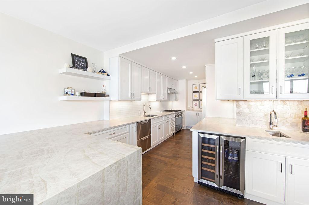 a large kitchen with stainless steel appliances kitchen island a large counter top and a sink