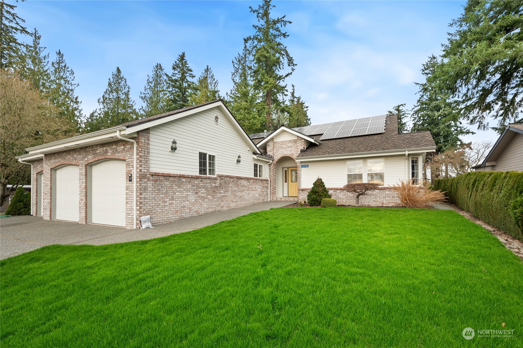 a front view of a house with a garden and yard