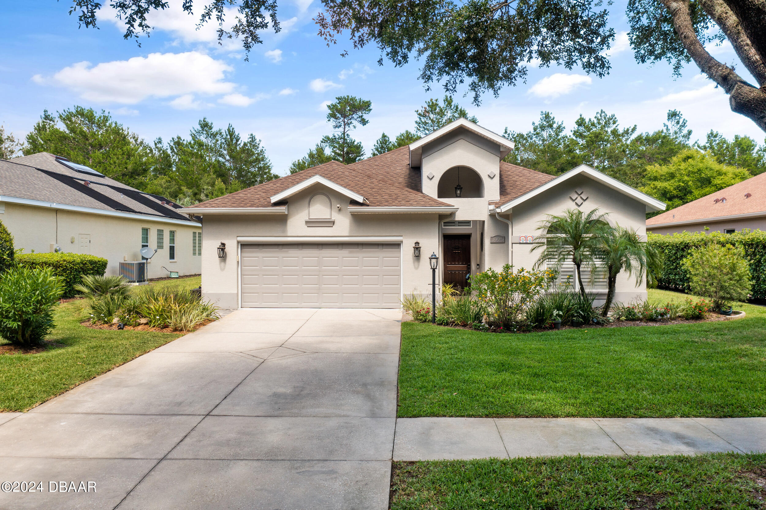 a front view of a house with a garden and plants