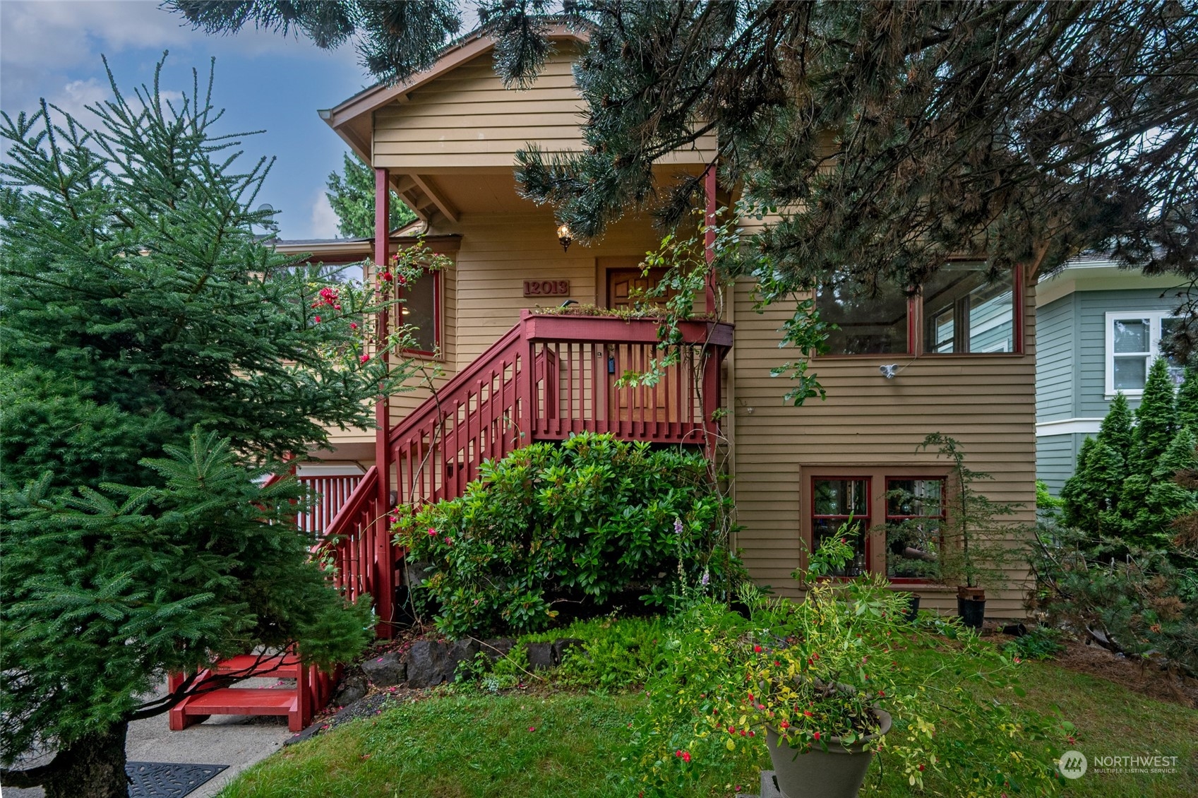 a front view of a house with plants and trees