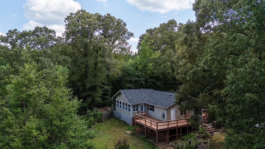 an aerial view of a house with a yard and large trees