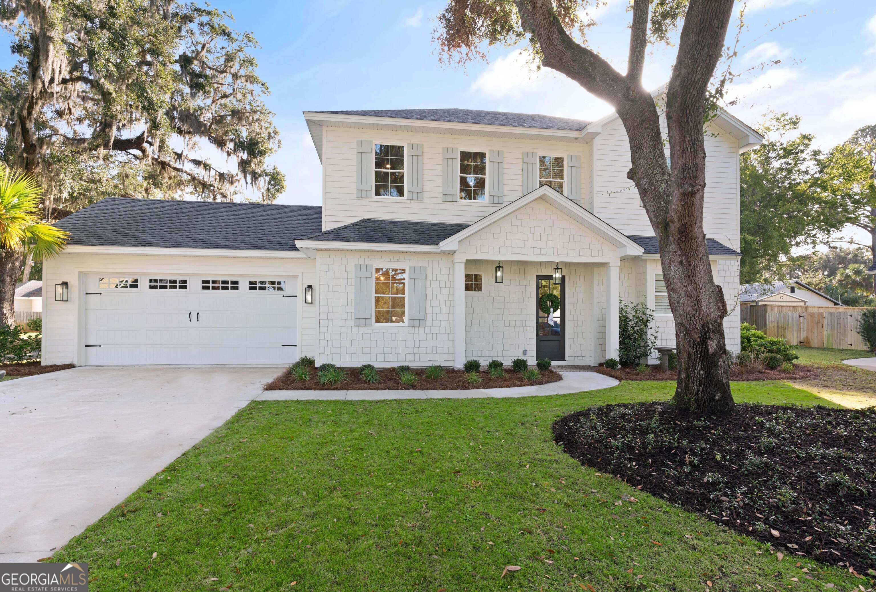 a front view of a house with a yard and trees