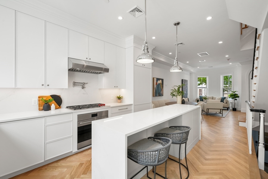 a large white kitchen with lots of counter space furniture and appliances