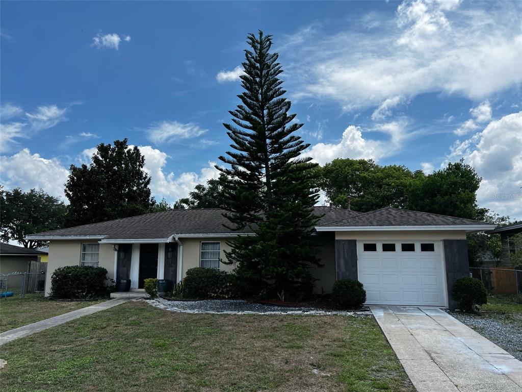 a front view of a house with a garden and trees