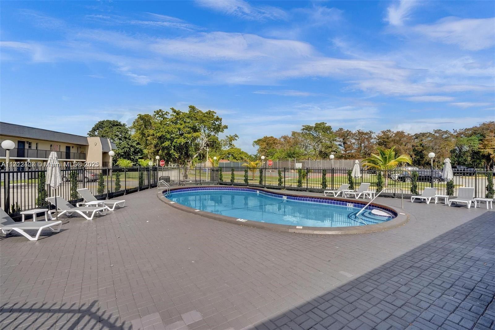 a view of a swimming pool with a patio and a yard