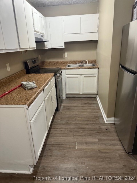 a kitchen with a sink a refrigerator and cabinets