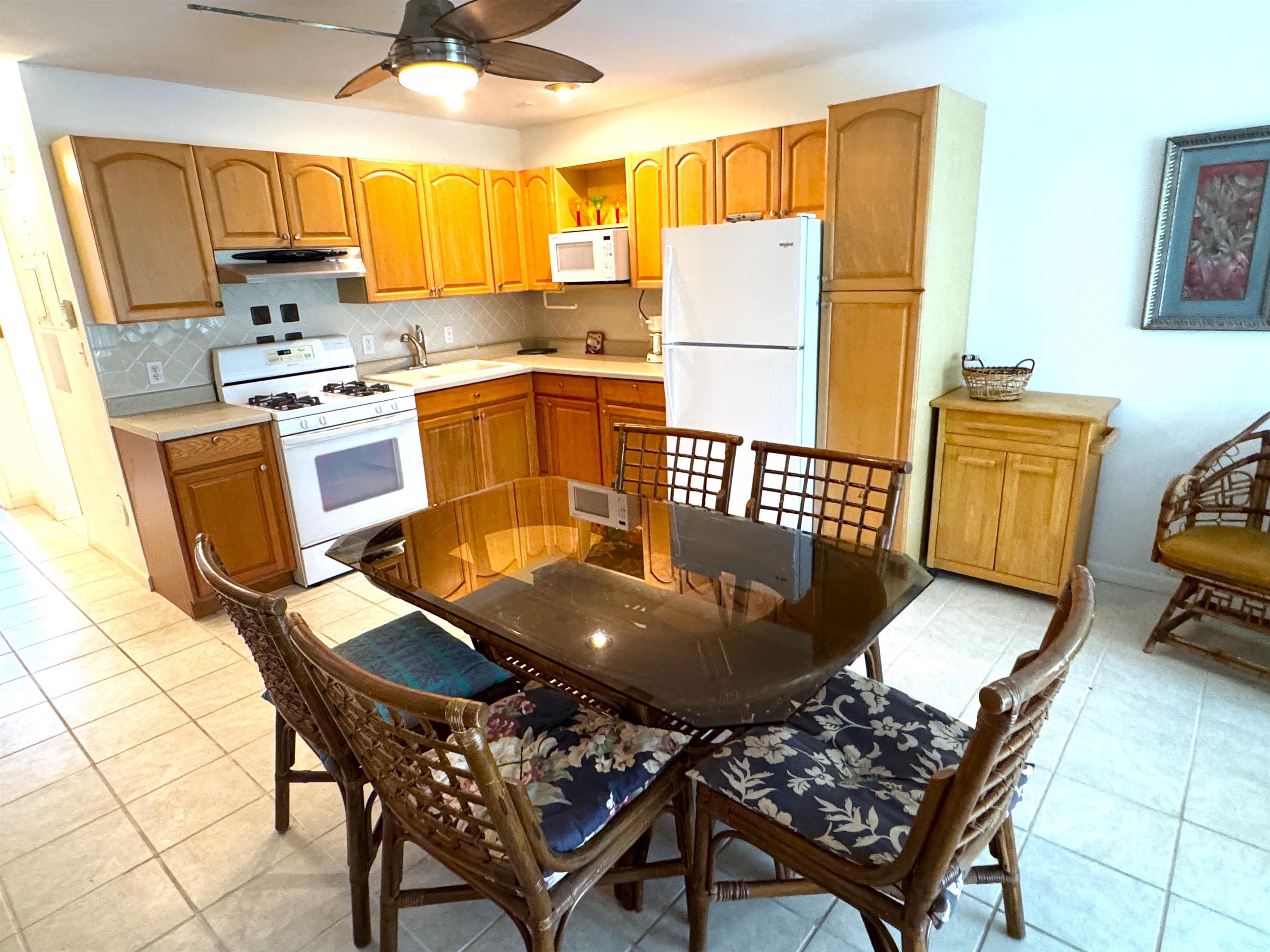 a kitchen with sink refrigerator dining table and chairs