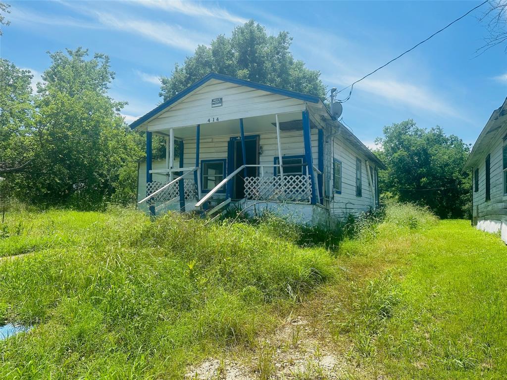 a house with green field in front of it