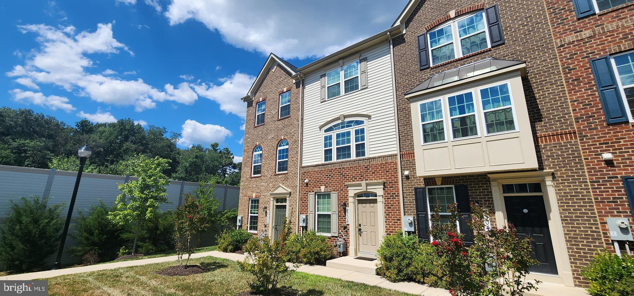 a front view of a multi story building with yard