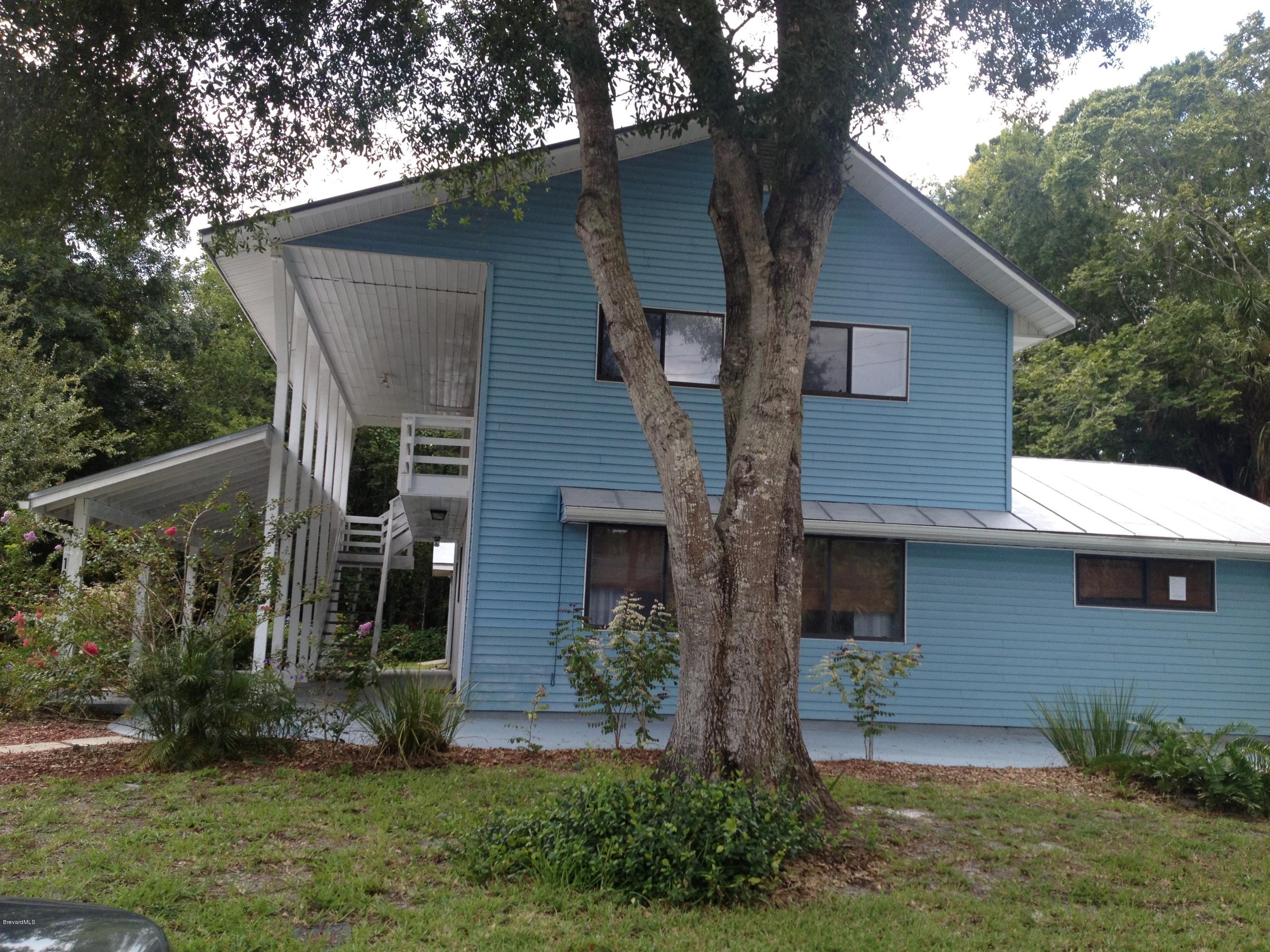 a front view of a house with a yard and tree