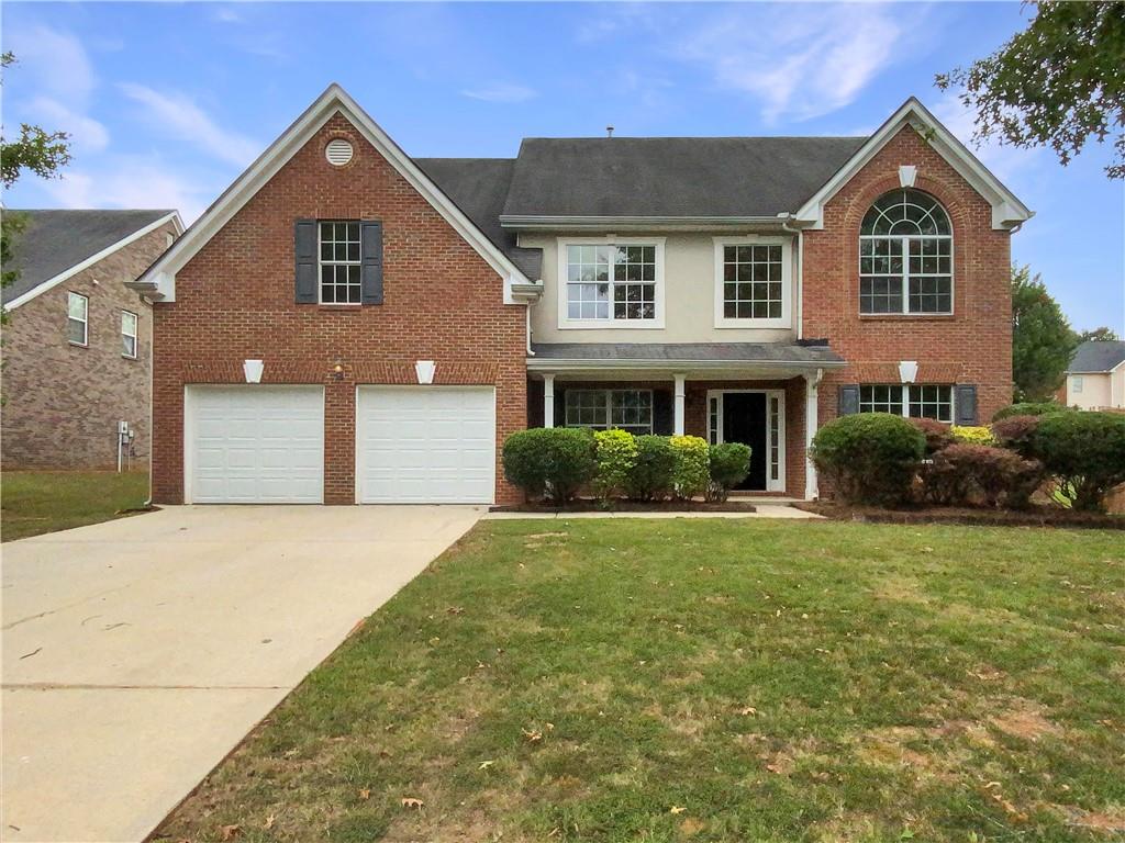 a front view of a house with a yard and garage