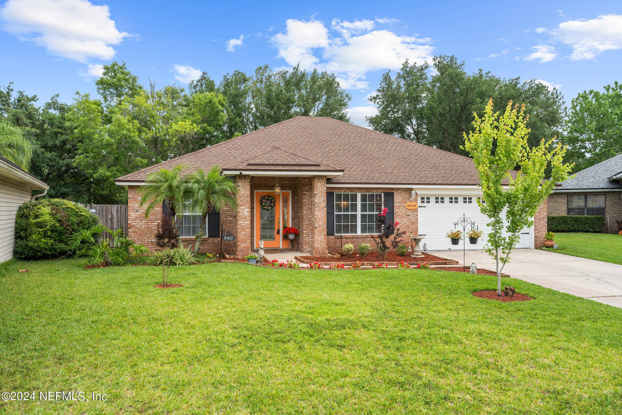 a front view of a house with a garden and trees