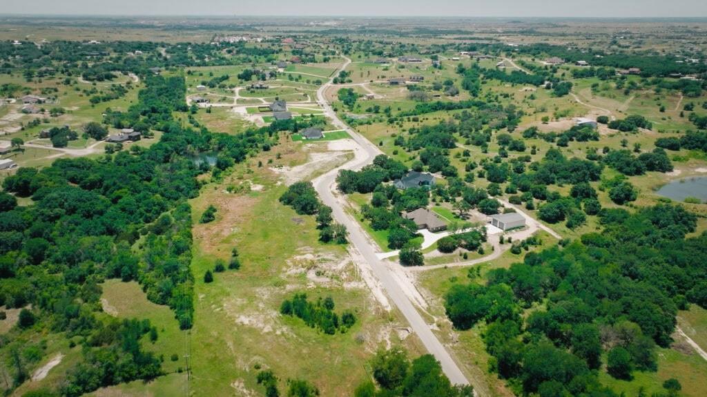 an aerial view of residential houses with outdoor space and trees