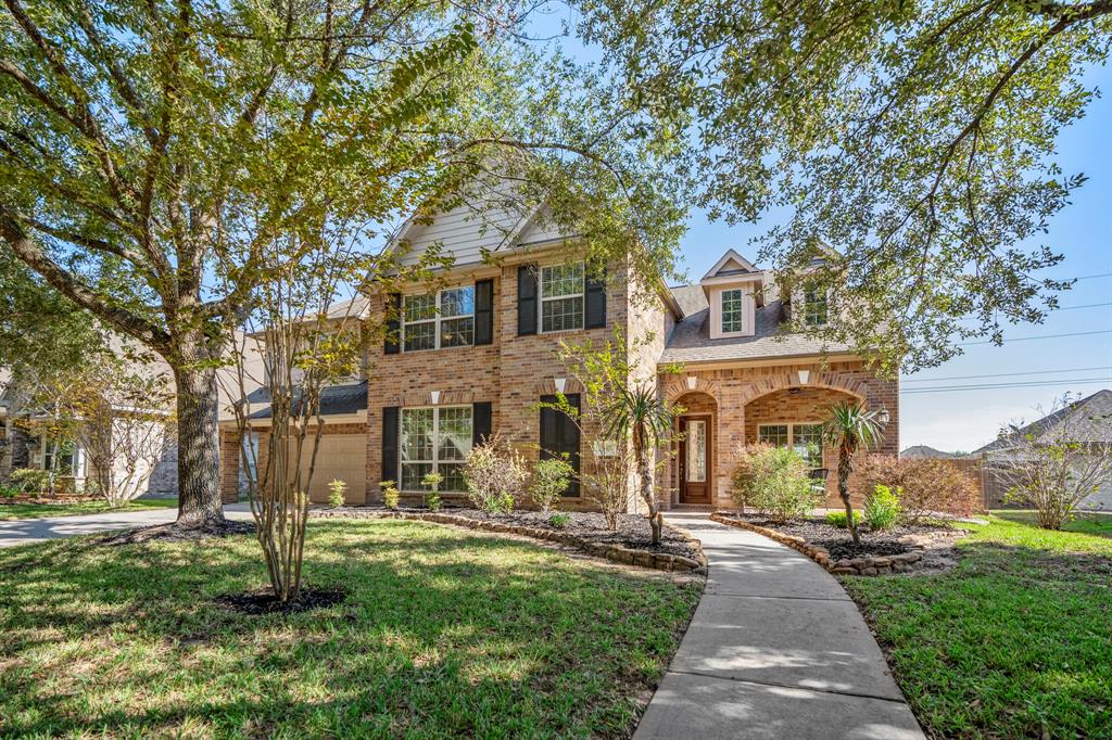 This charming two-story brick home features freshly groomed mature trees and offers a serene suburban setting.