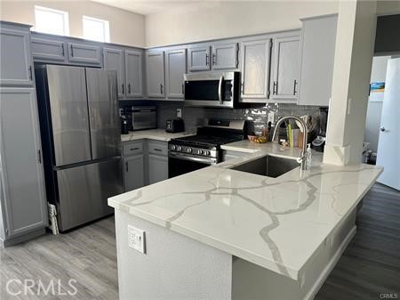 a kitchen with stainless steel appliances a refrigerator stove microwave and sink