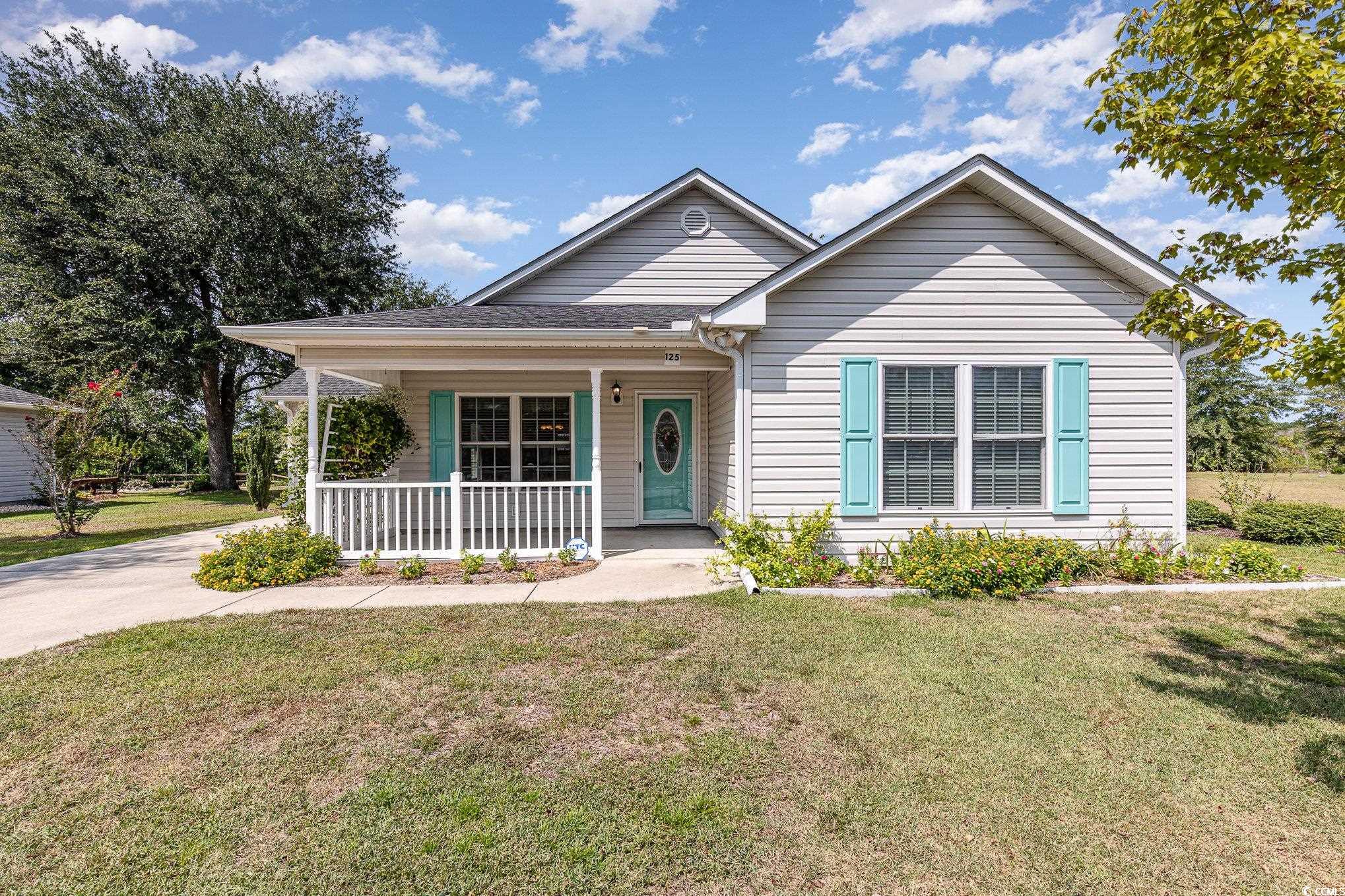 View of front of home with a front yard and a porc