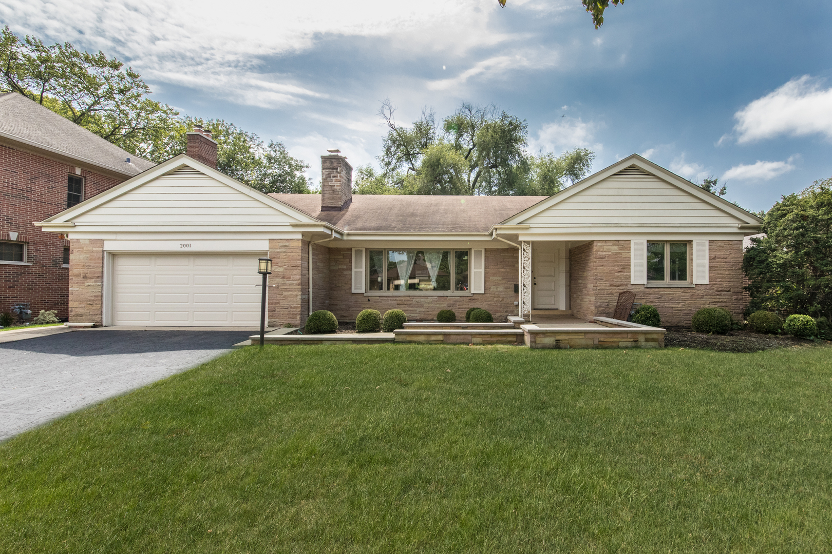 a front view of a house with a garden and patio