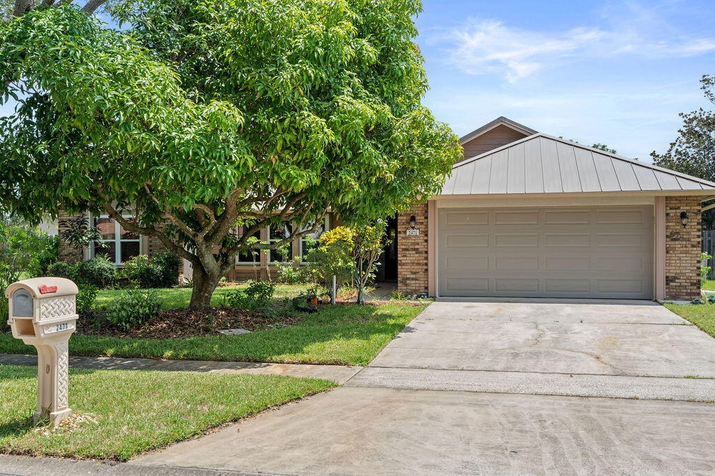 a front view of a house with a yard and trees