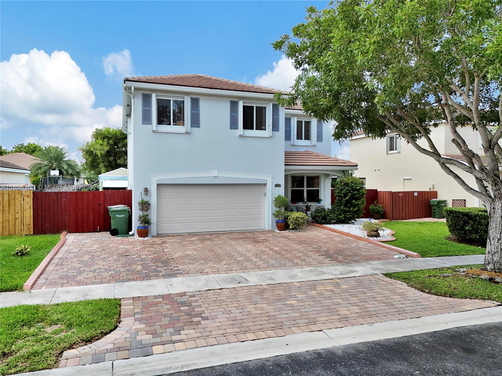 a front view of a house with a yard and a garage