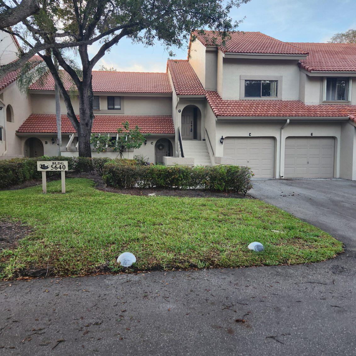 a front view of a house with a garden and plants