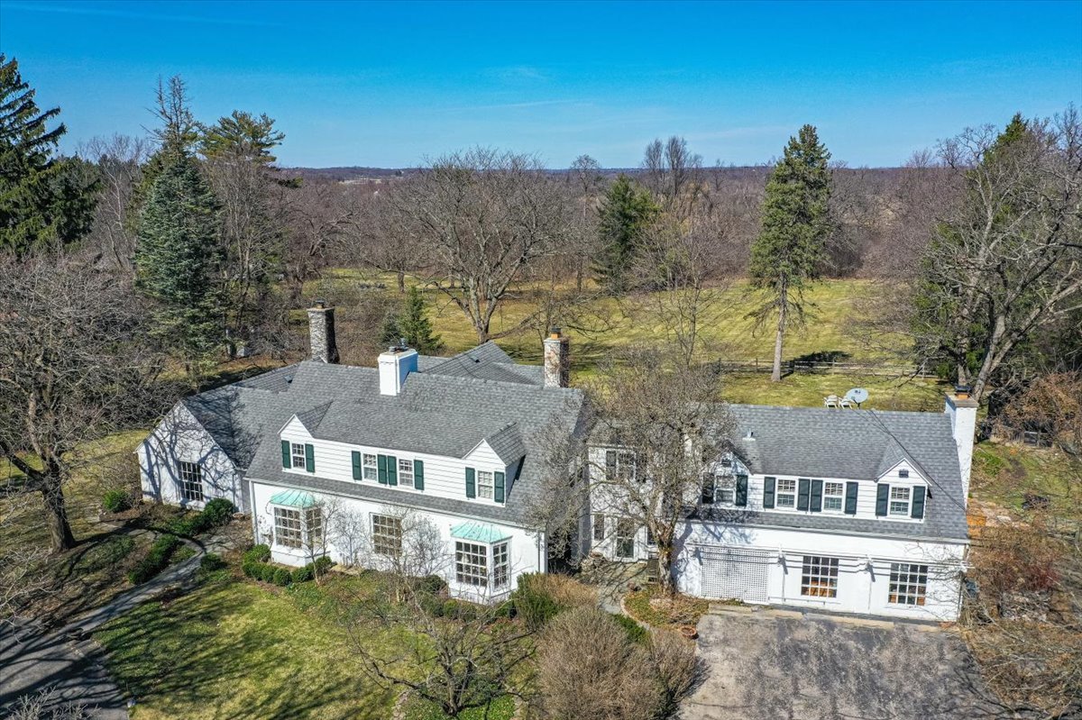 aerial view of a house with a yard and mountain view in back