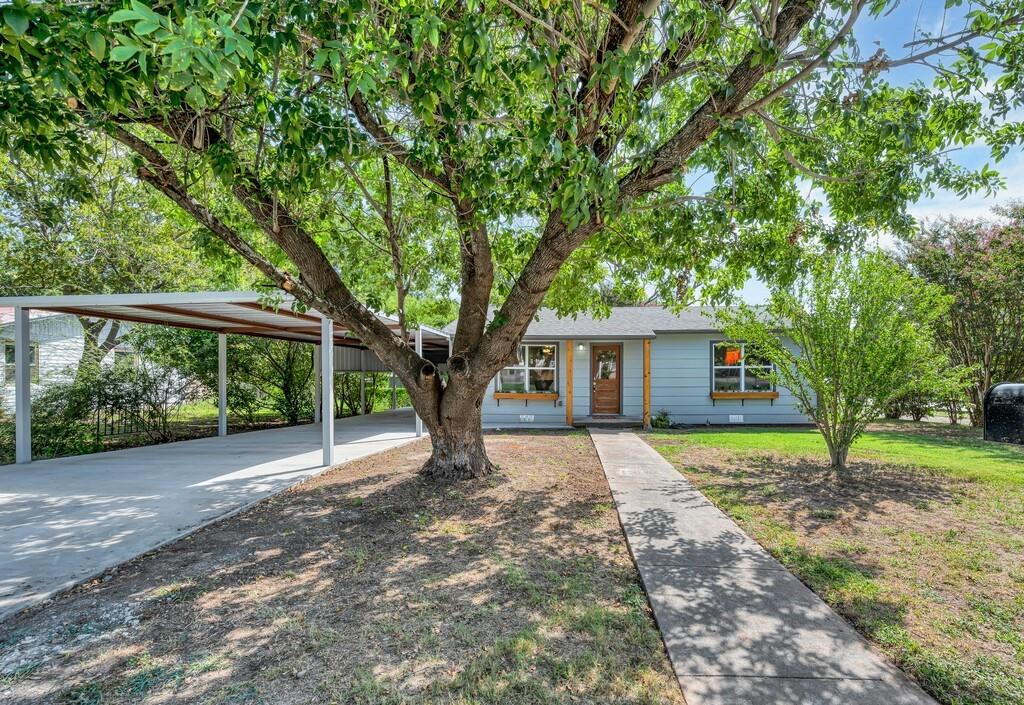 a view of a house with a yard and tree