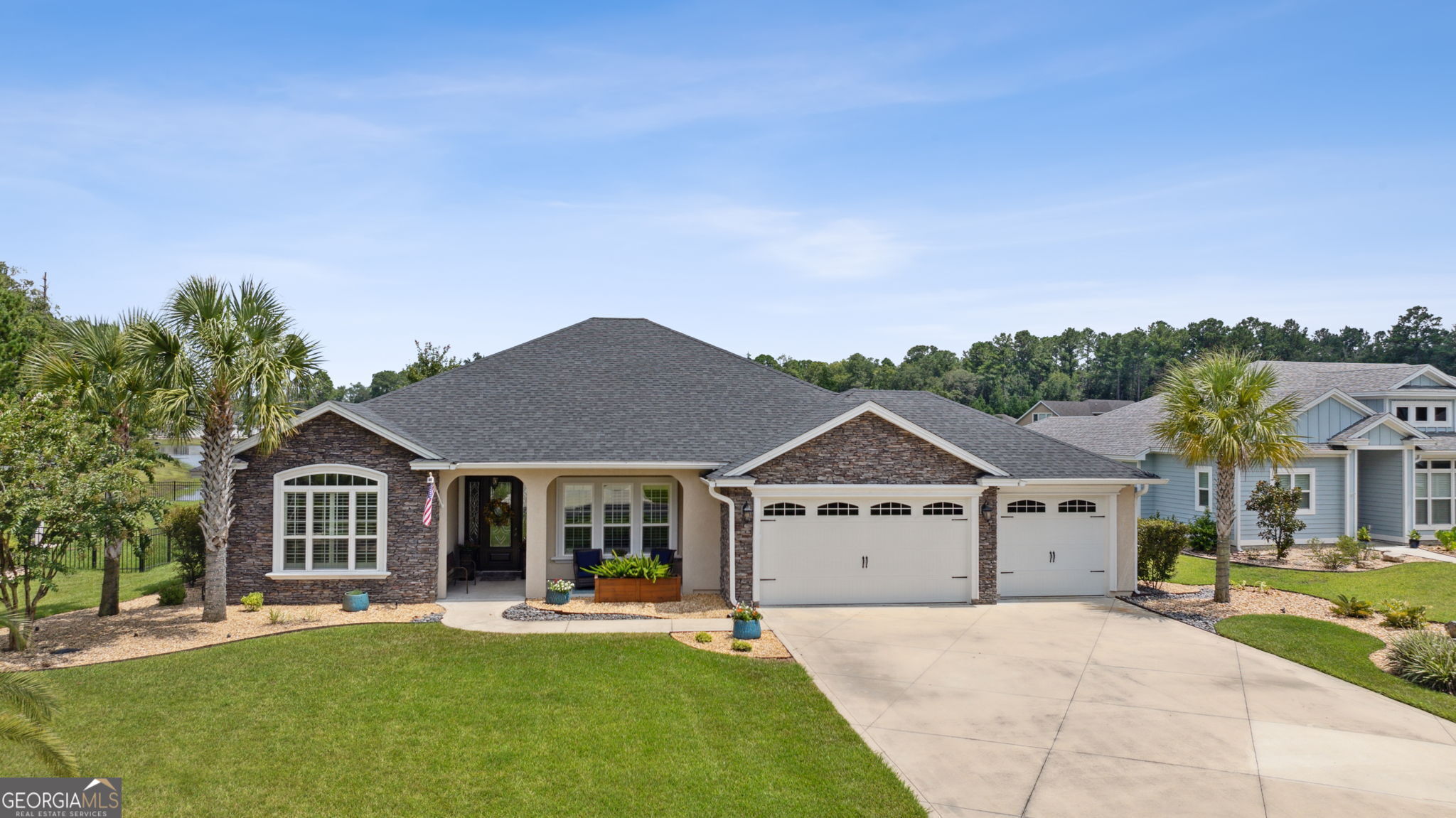 a front view of a house with a garden and yard