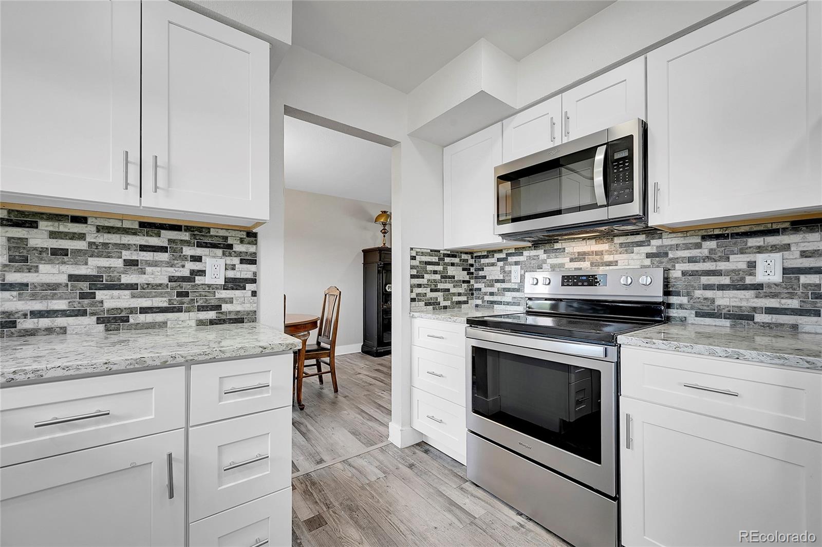 a kitchen with stainless steel appliances granite countertop a stove microwave and cabinets