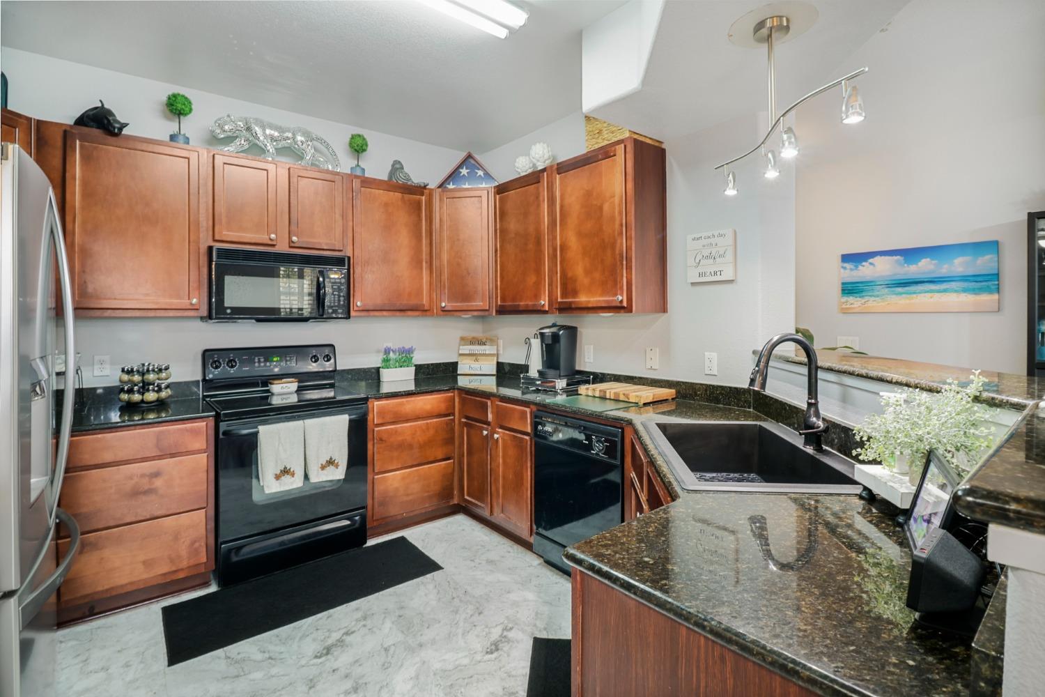 a kitchen with granite countertop a sink and a stove top oven