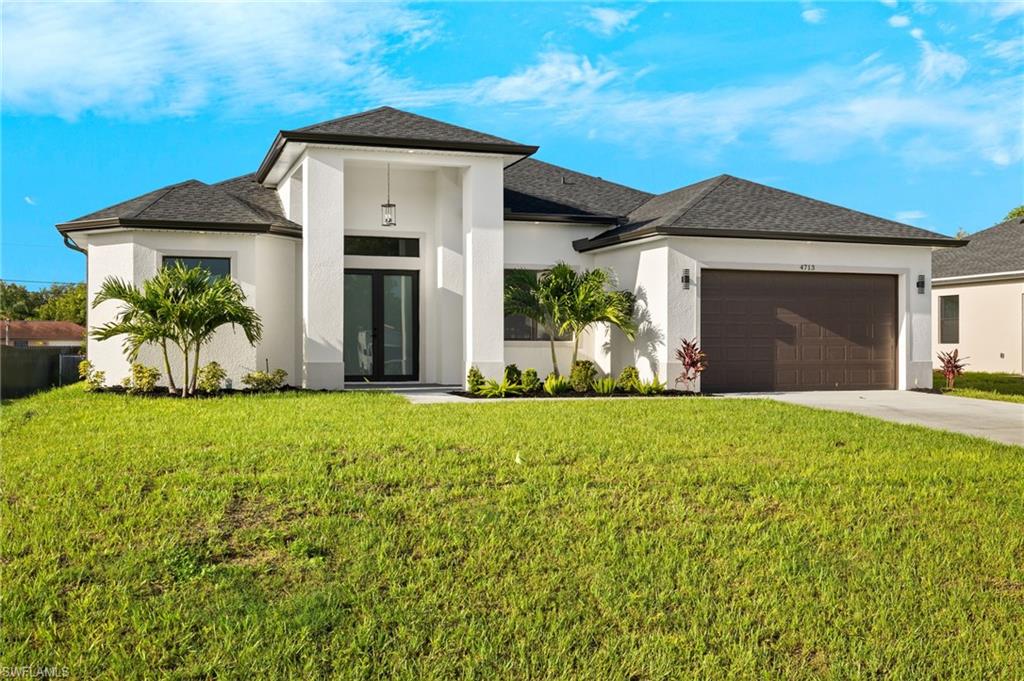 Front view of property with front lawn and a 2 car garage