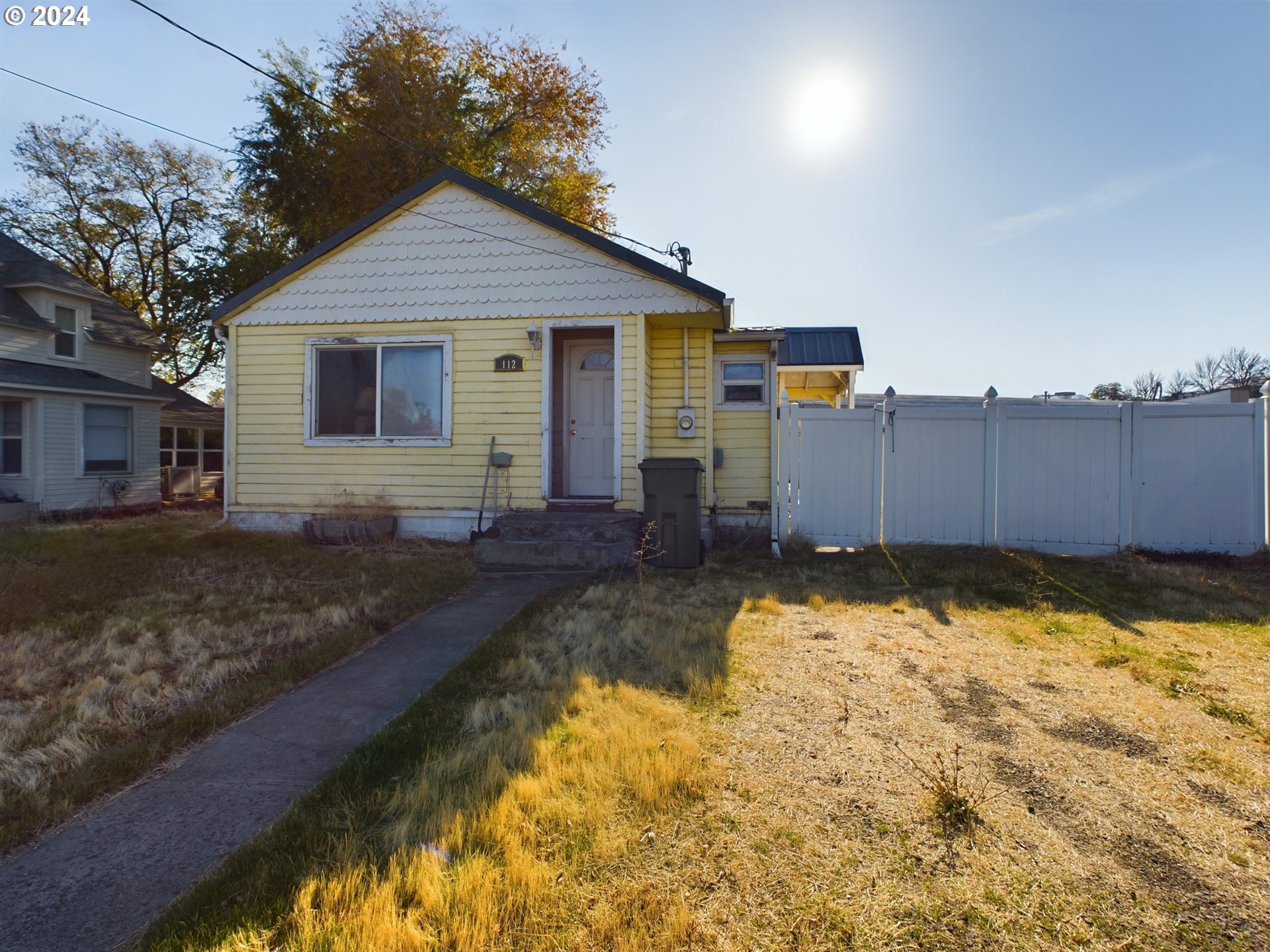 a front view of a house with a yard covered with snow