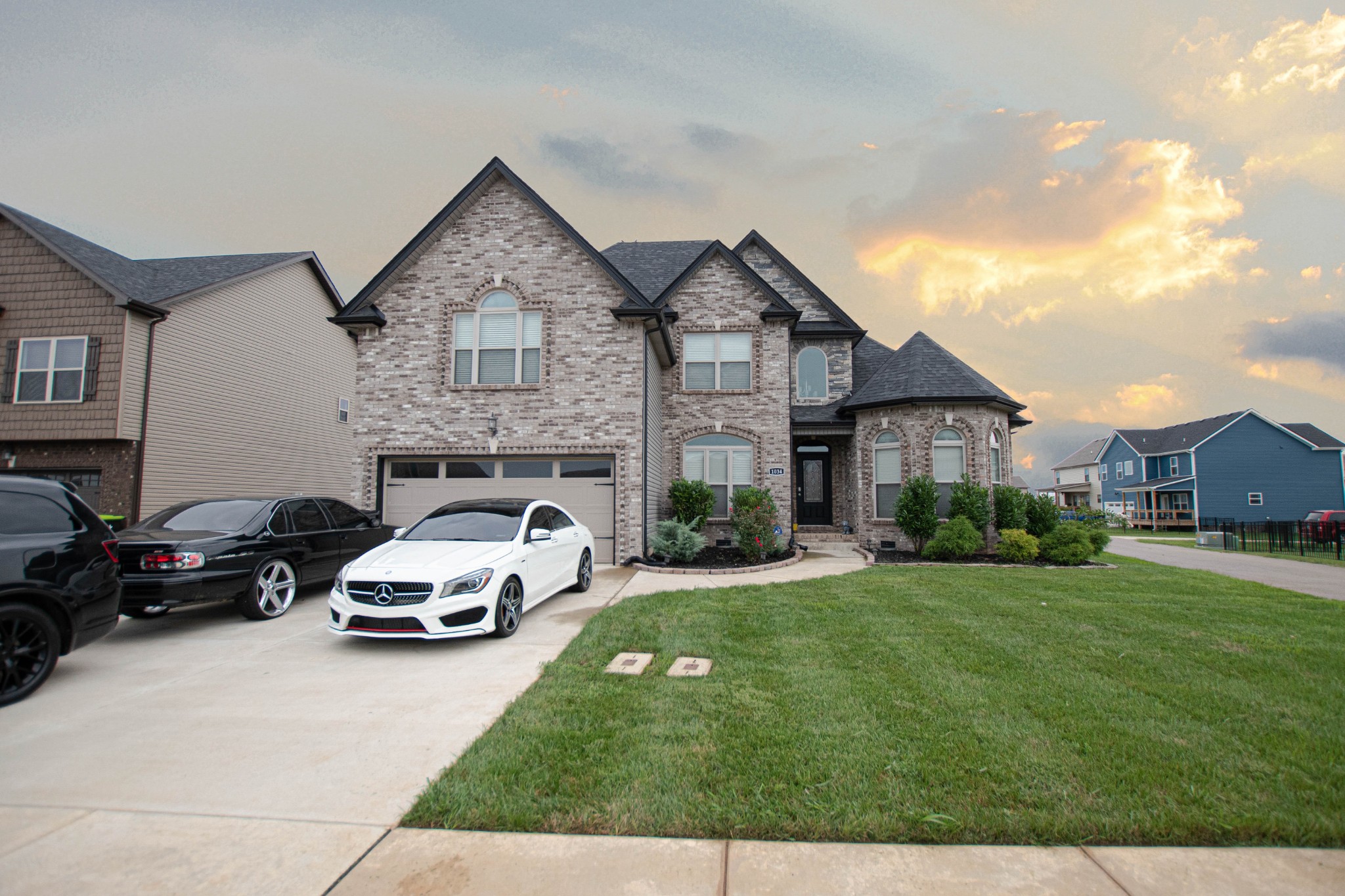 a car parked in front of a house with a yard