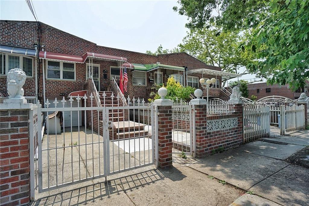 a view of house with a small yard and wooden fence