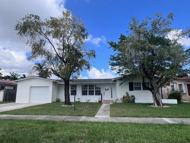 a front view of a house with a yard and trees