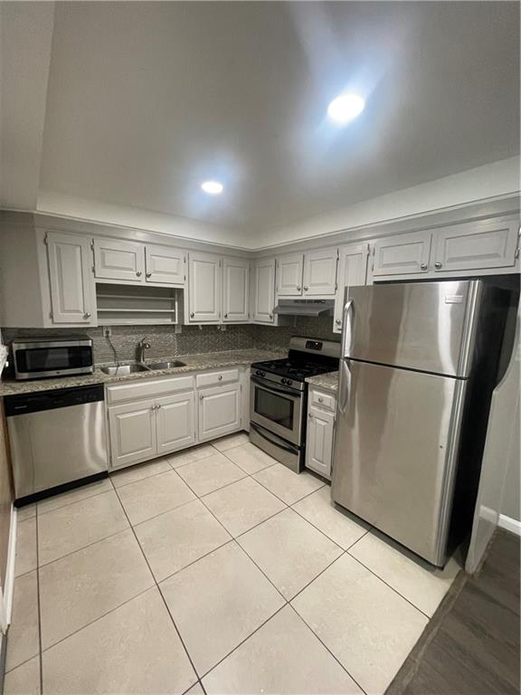 a kitchen with cabinets stainless steel appliances and a counter space