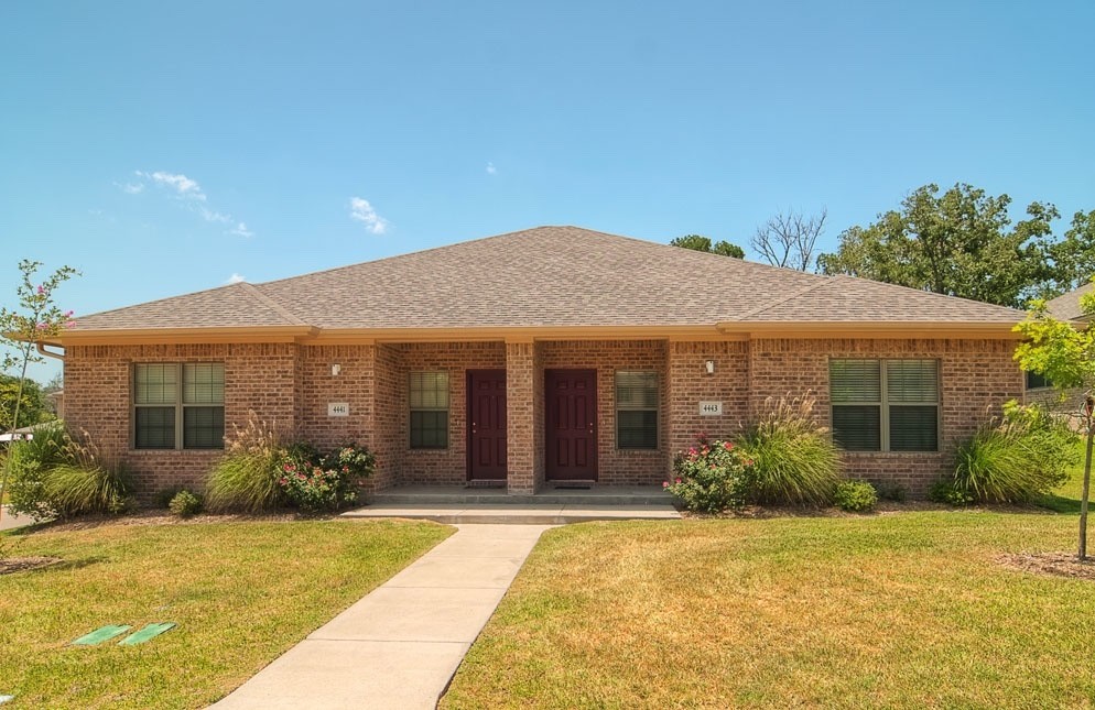 Ranch-style house featuring a porch and a front ya