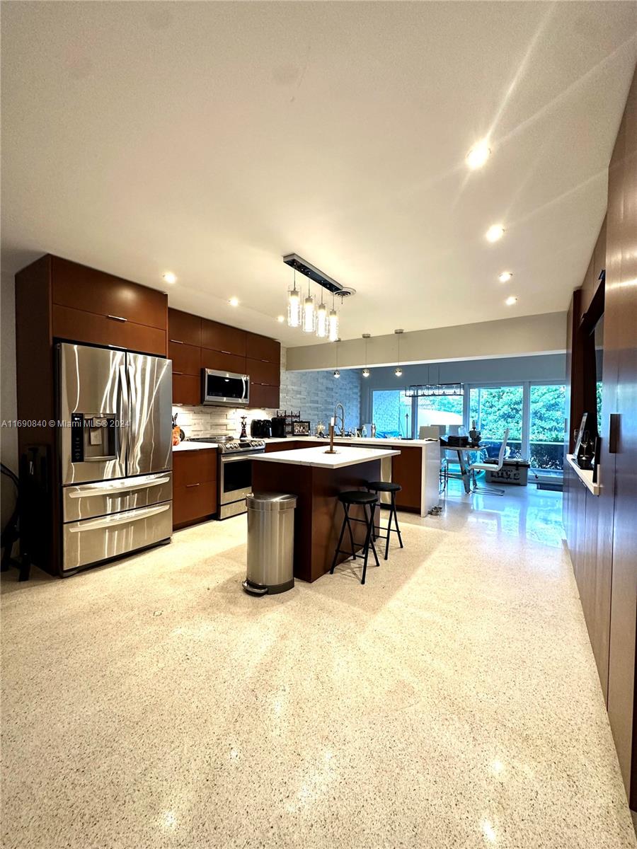 a kitchen with stainless steel appliances kitchen island granite countertop a sink and cabinets