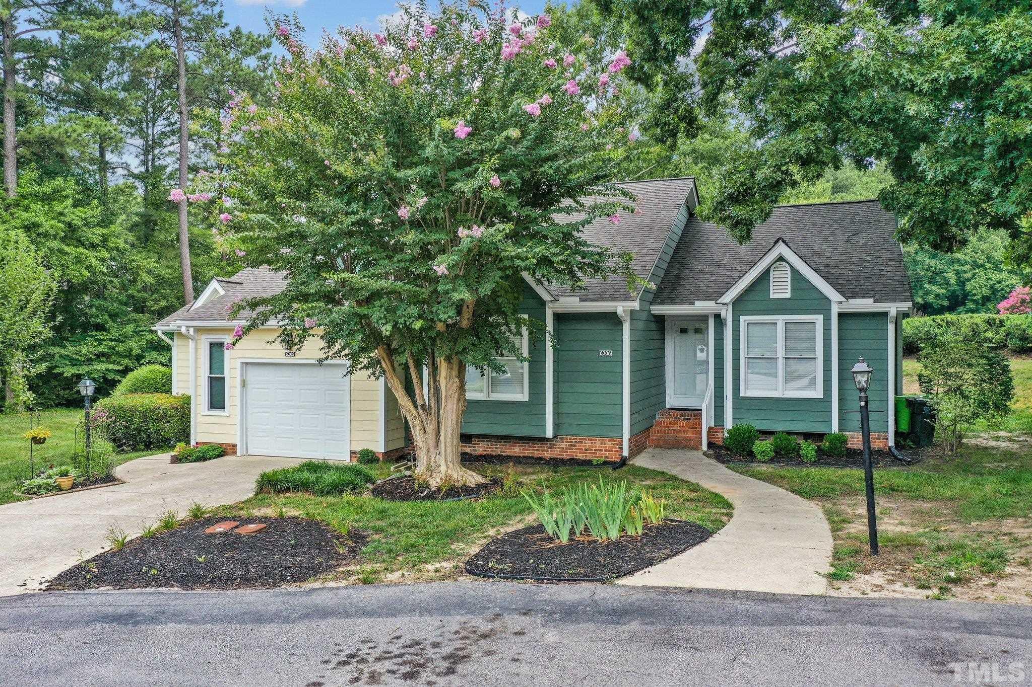 a front view of a house with a yard and potted plants