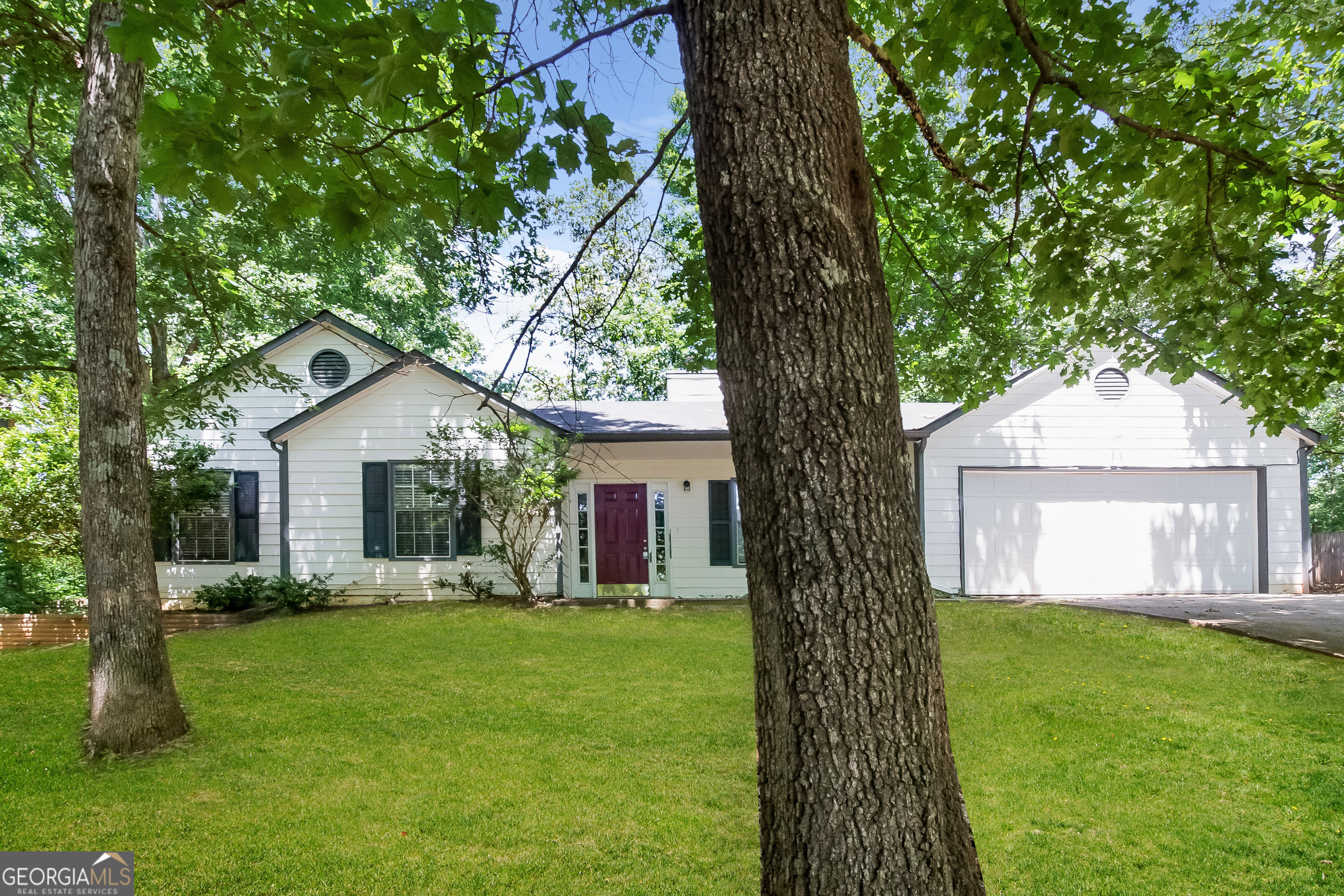 a front view of house with a garden and trees